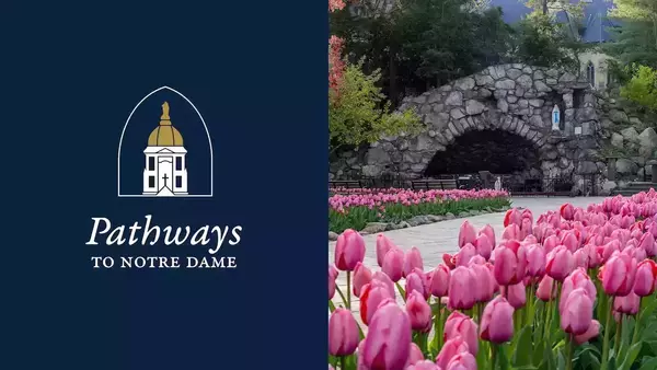 Pathways to Notre Dame logo beside the grotto, surrounded by vibrant pink tulips.
